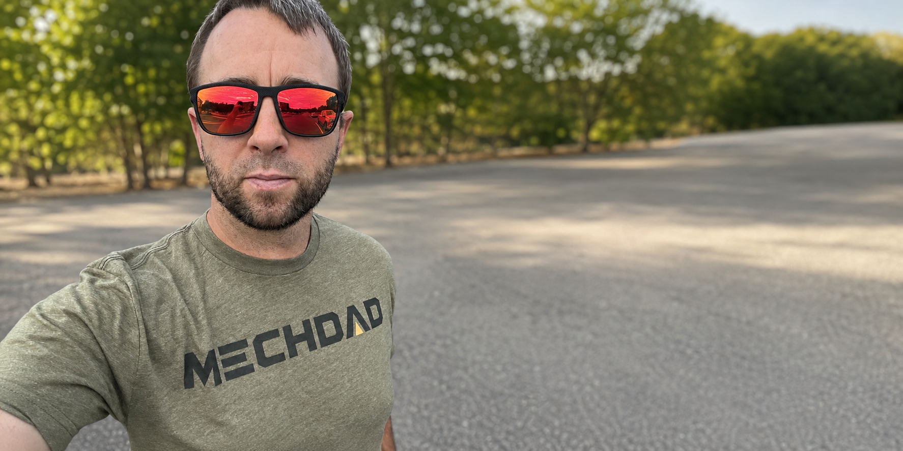 Man wearing an olive MECHDAD shirt outdoors